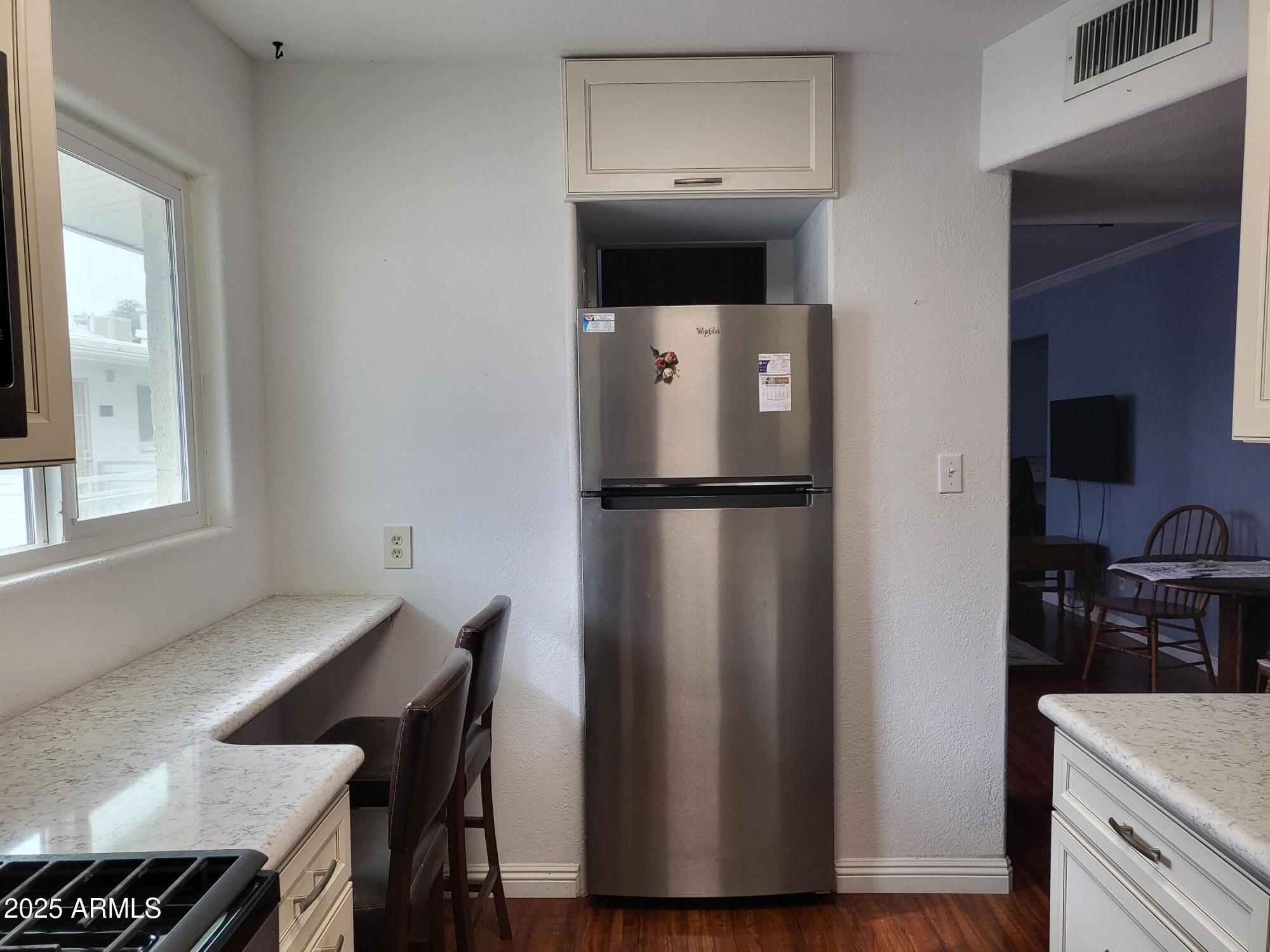 815 North Hayden Road, Unit D207 Scottsdale, AZ 85257 - Photo 12 of 29 a kitchen with a refrigerator and wooden floor