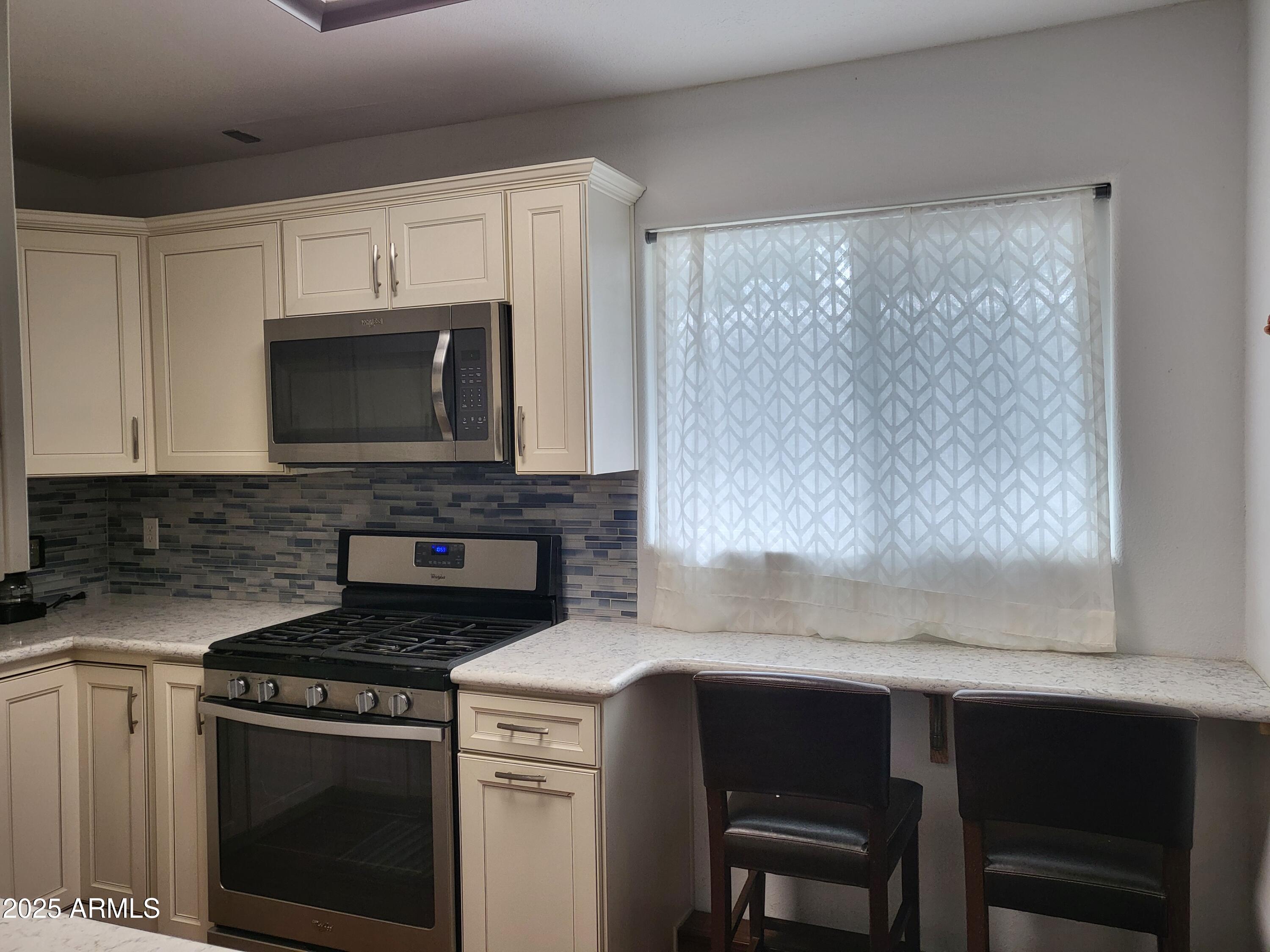 815 North Hayden Road, Unit D207 Scottsdale, AZ 85257 - Photo 14 of 29 a kitchen with granite countertop a stove microwave and oven