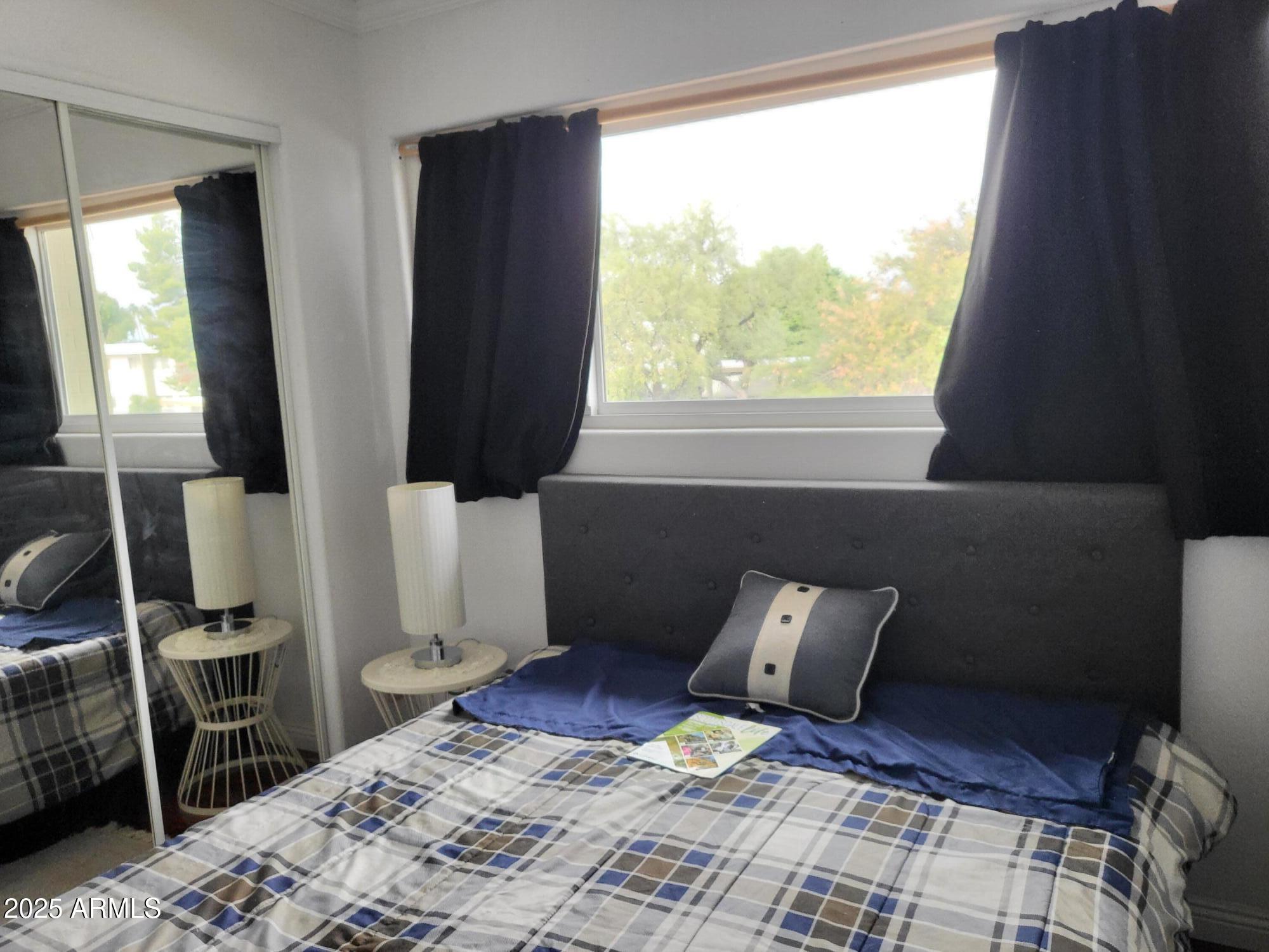 815 North Hayden Road, Unit D207 Scottsdale, AZ 85257 - Photo 21 of 29 a bedroom with a bed and wooden floor