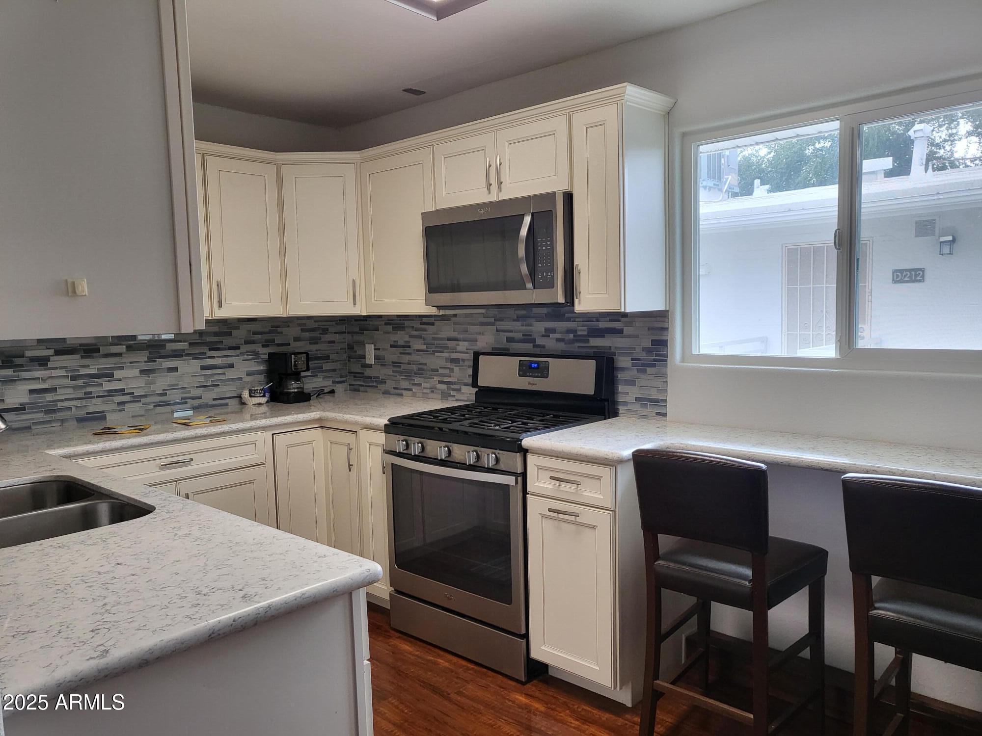 815 North Hayden Road, Unit D207 Scottsdale, AZ 85257 - Photo 9 of 29 a kitchen with a stove a sink and a microwave