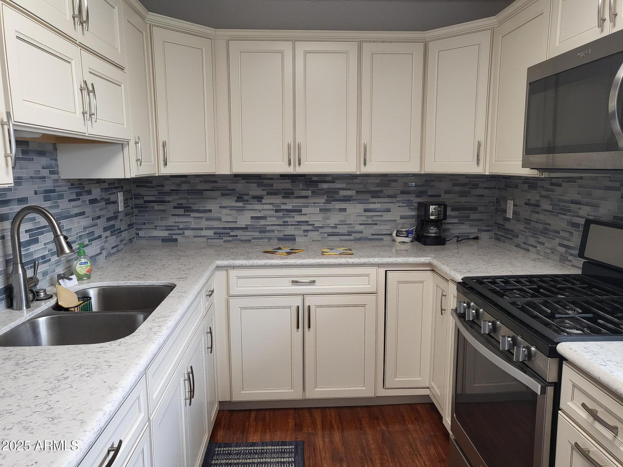 815 North Hayden Road, Unit D207 Scottsdale, AZ 85257 - Photo 10 of 29 a kitchen with granite countertop a sink stove and cabinets