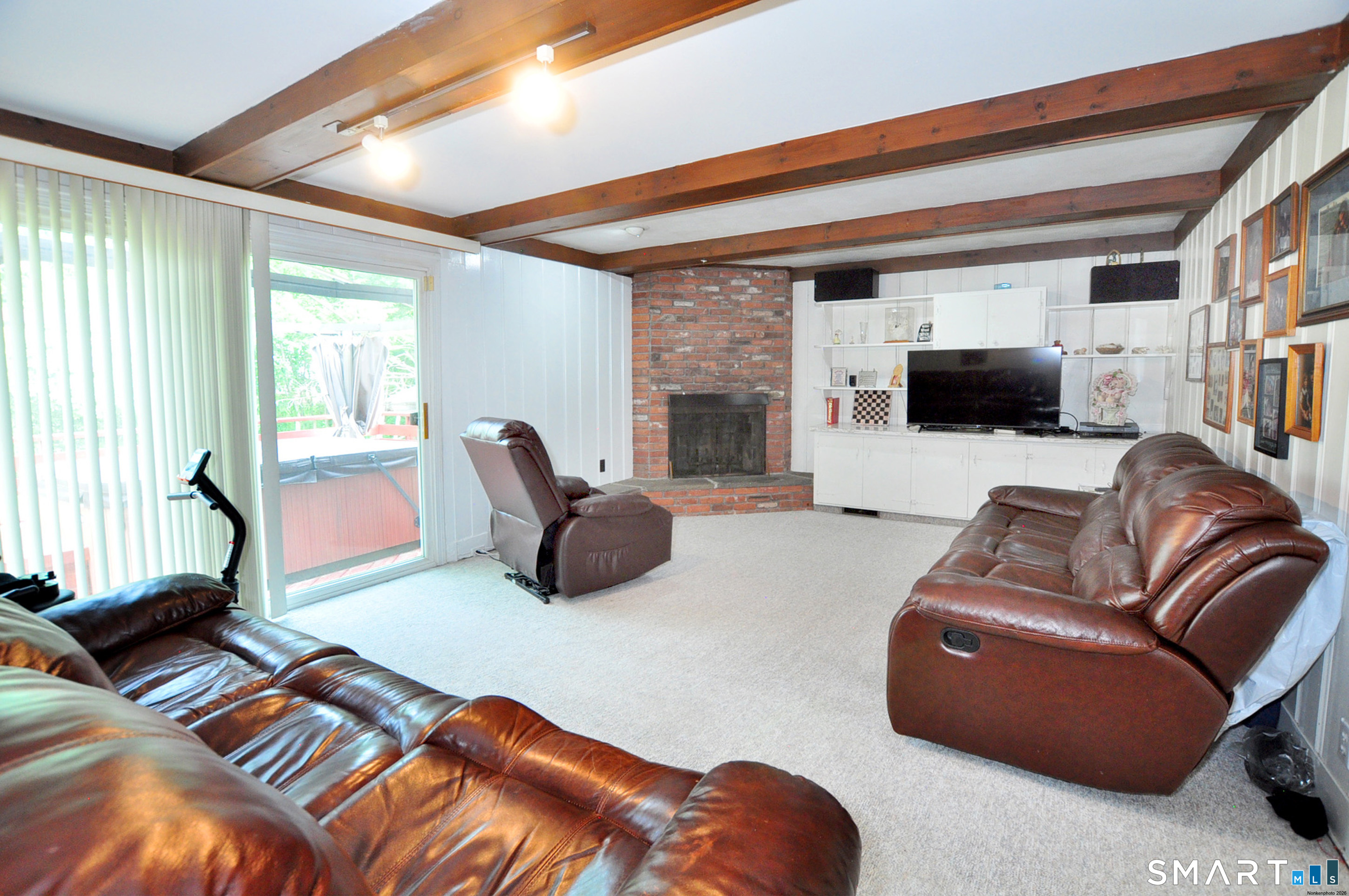16 Miamis Road West Hartford, CT 06117 - Photo 19 of 39 A cozy den with exposed brick wall, fireplace and built in cabinets offers a great space to relax, read or watch a movie. Sliders lead to the hot tub on the back deck