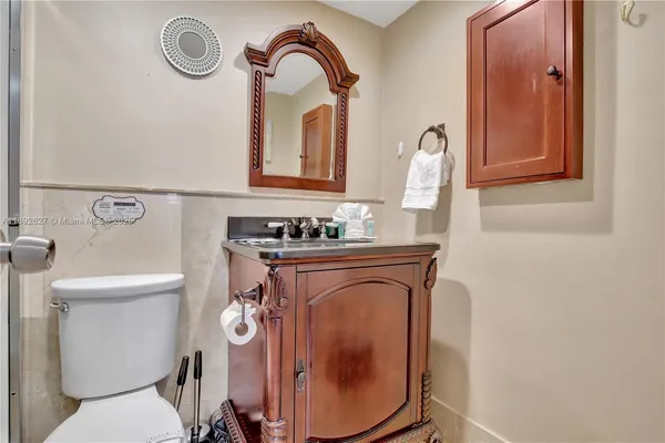 a bathroom with a toilet mirror vanity and a sink