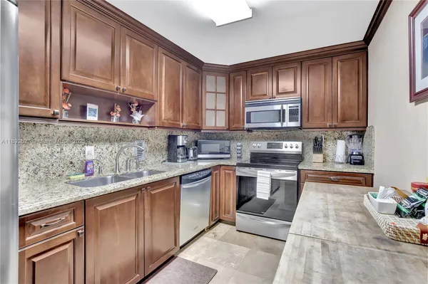 a kitchen with stainless steel appliances granite countertop a stove top oven a sink dishwasher and cabinets with wooden floor
