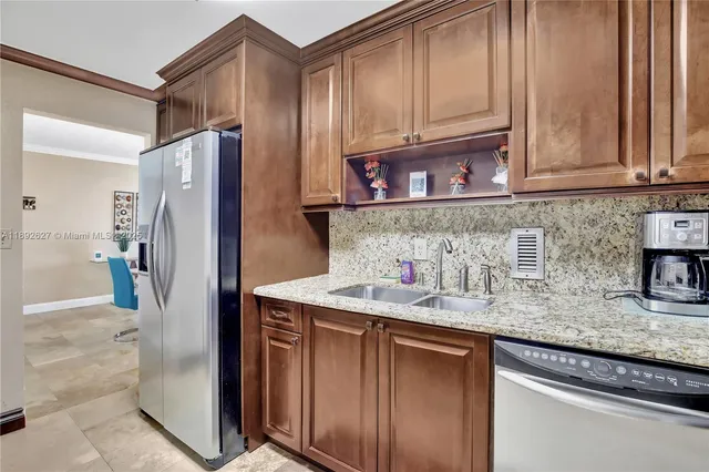 a kitchen with stainless steel appliances granite countertop a refrigerator and a sink