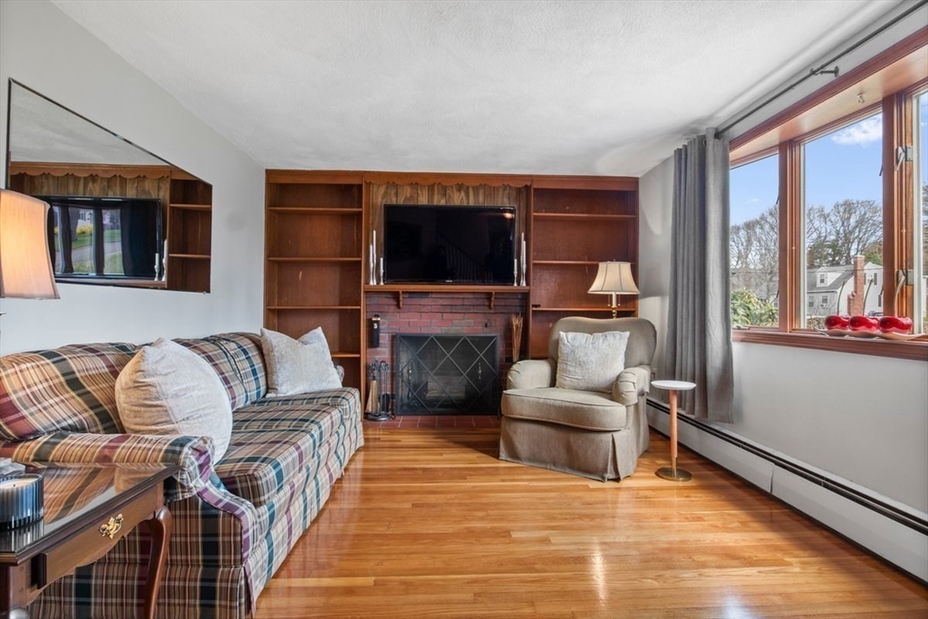 47 Irving Drive Walpole, MA 02081 - Photo 17 of 42 a living room with furniture a flat screen tv and a fireplace
