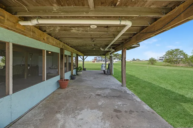 a view of a porch with furniture and a yard