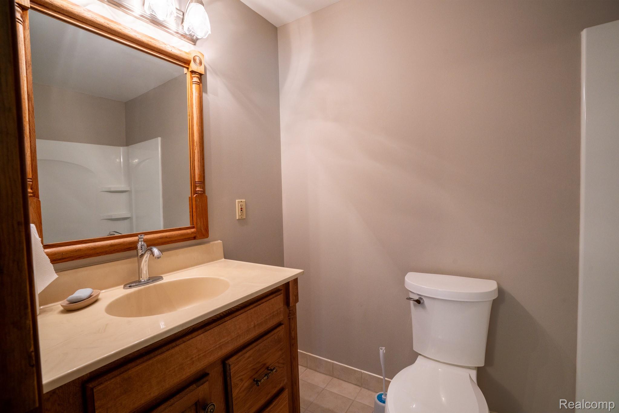 12900 Maxwell Road Carleton, MI 48117 - Photo 46 of 59 Wood-finish vanity with an integrated sink and light-toned countertop