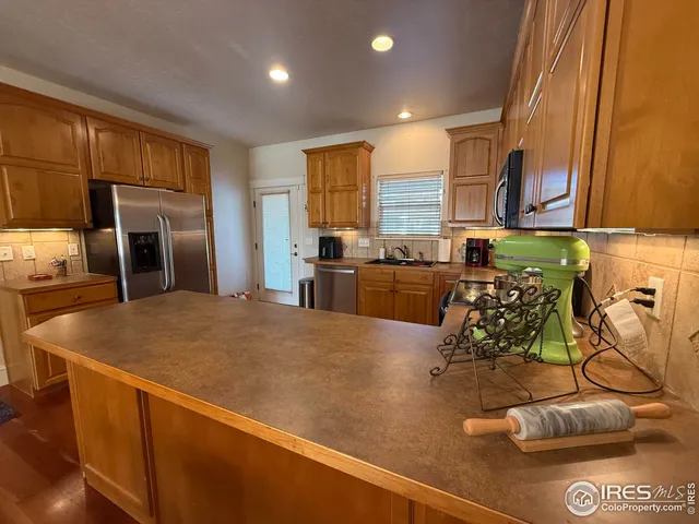 a kitchen with stainless steel appliances granite countertop a sink and a refrigerator