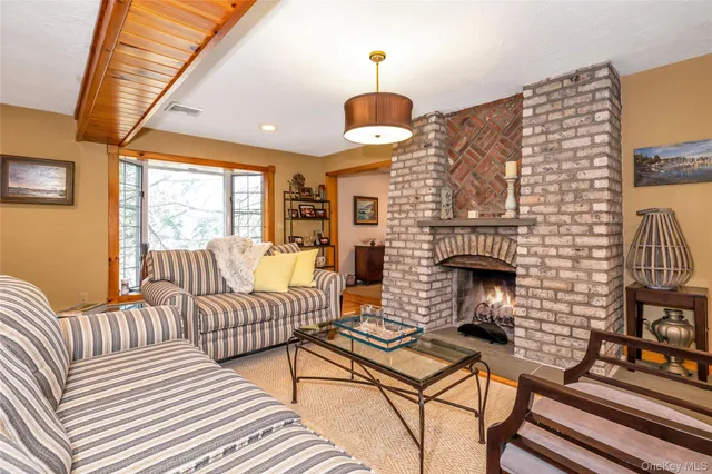 a living room with furniture a fireplace and a large window