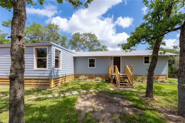 a backyard of a house with table and chairs