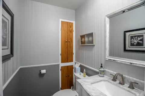 a bathroom with a sink mirror vanity and toilet
