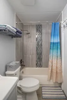 a bathroom with a sink a toilet a bathtub and shower