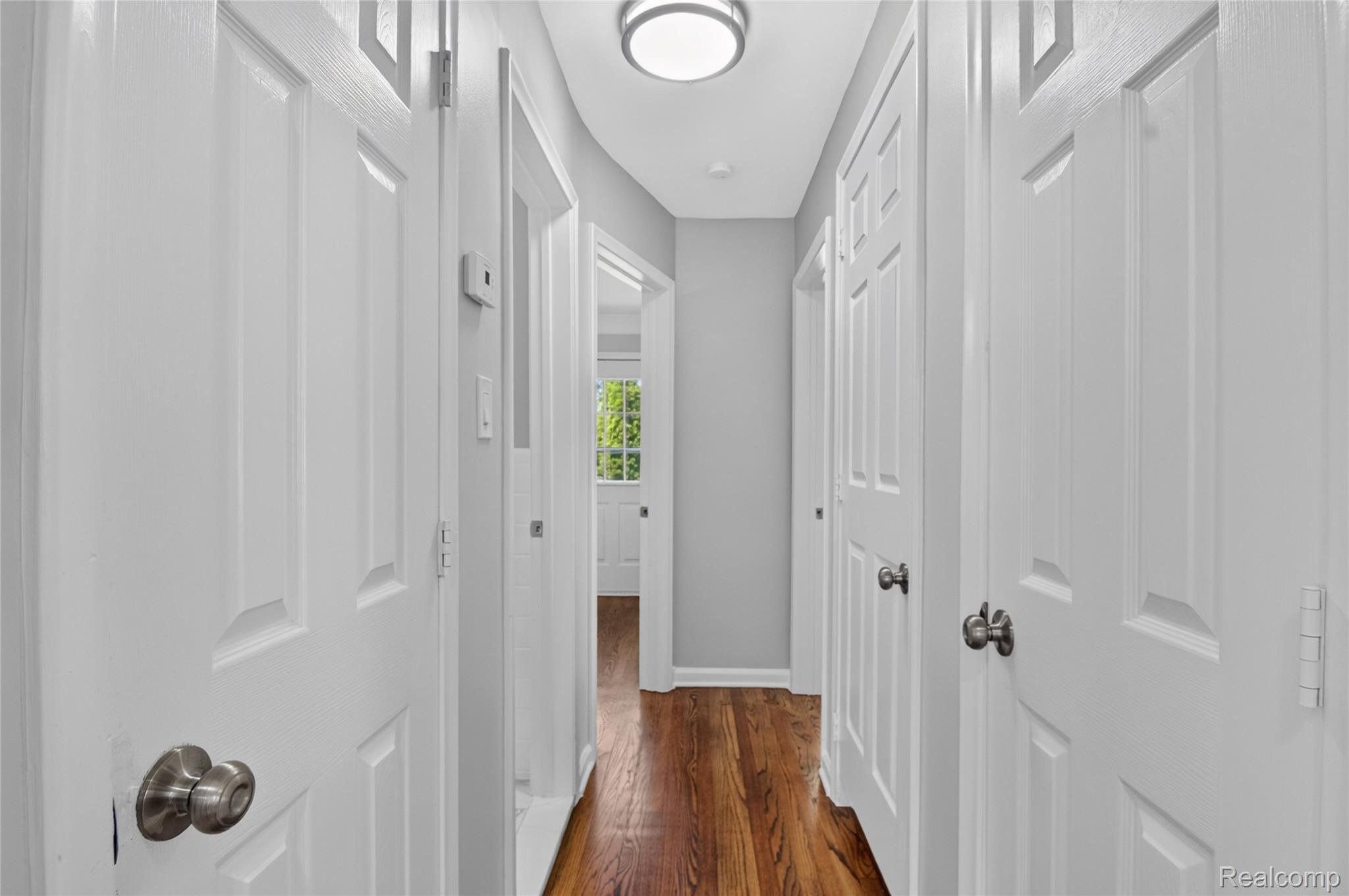 12972 Callender Street Southgate, MI 48195 - Photo 18 of 40 Hallway with rich wood-finish flooring, white paneled doors, and a flush-mount ceiling light fixture