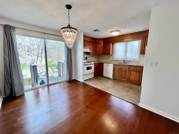 a open kitchen with stainless steel appliances granite countertop a stove top oven a sink and a wooden floor