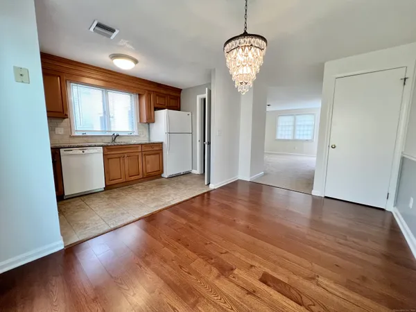 a view of large kitchen with granite countertop stainless steel appliances and wooden floor