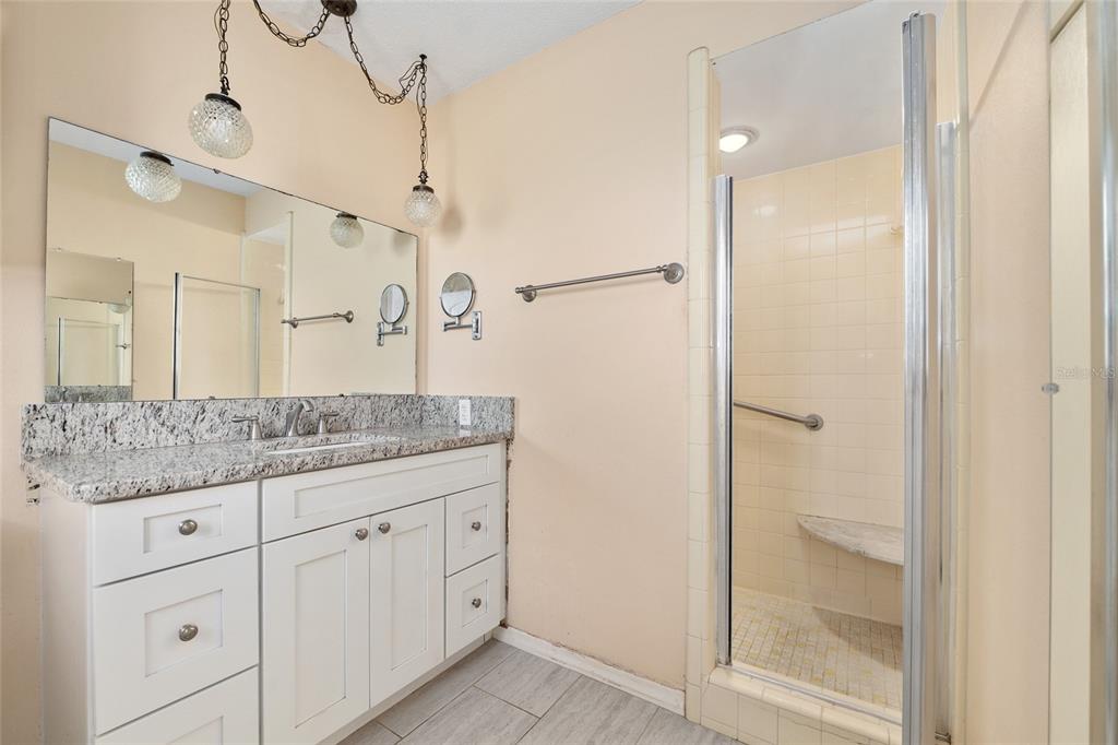 3300 Southeast 32nd Street Ocala, FL 34471 - Photo 27 of 51 a bathroom with a granite countertop sink two mirror and shower