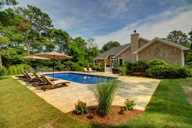 a view of a house with swimming pool and sitting area