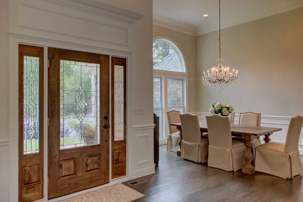 a dining room with furniture a chandelier and wooden floor