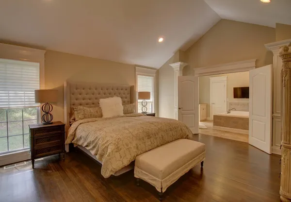 a bedroom with a bed and wooden floor