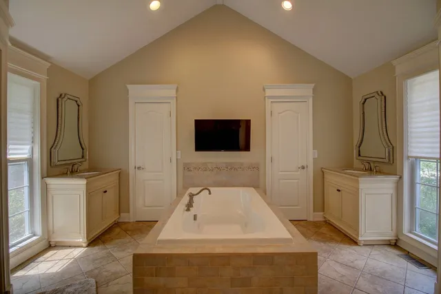 a living room with furniture a flat screen tv and a refrigerator