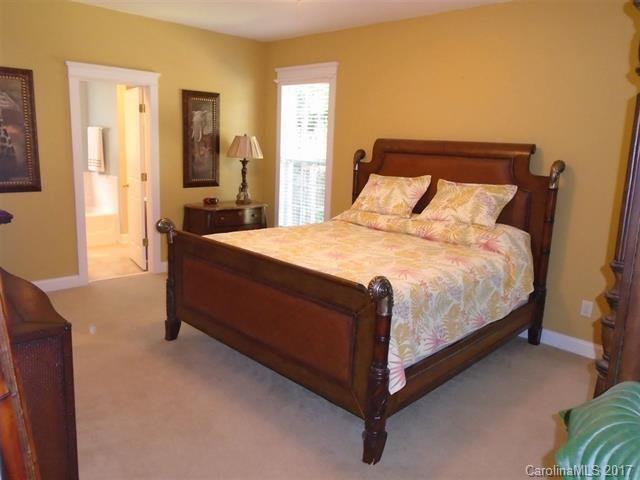 1512 Calvin Hall Road, Unit 161 Lake Wylie, SC 29710 - Photo 11 of 24 a large bed sitting in a bedroom next to a window with a dresser and mirror