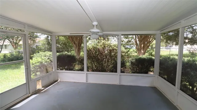 a view of an empty room with wooden floor and a floor to ceiling window
