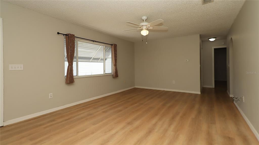 10860 Southwest 62nd Avenue Ocala, FL 34476 - Photo 4 of 35 a view of an empty room with wooden floor and a window