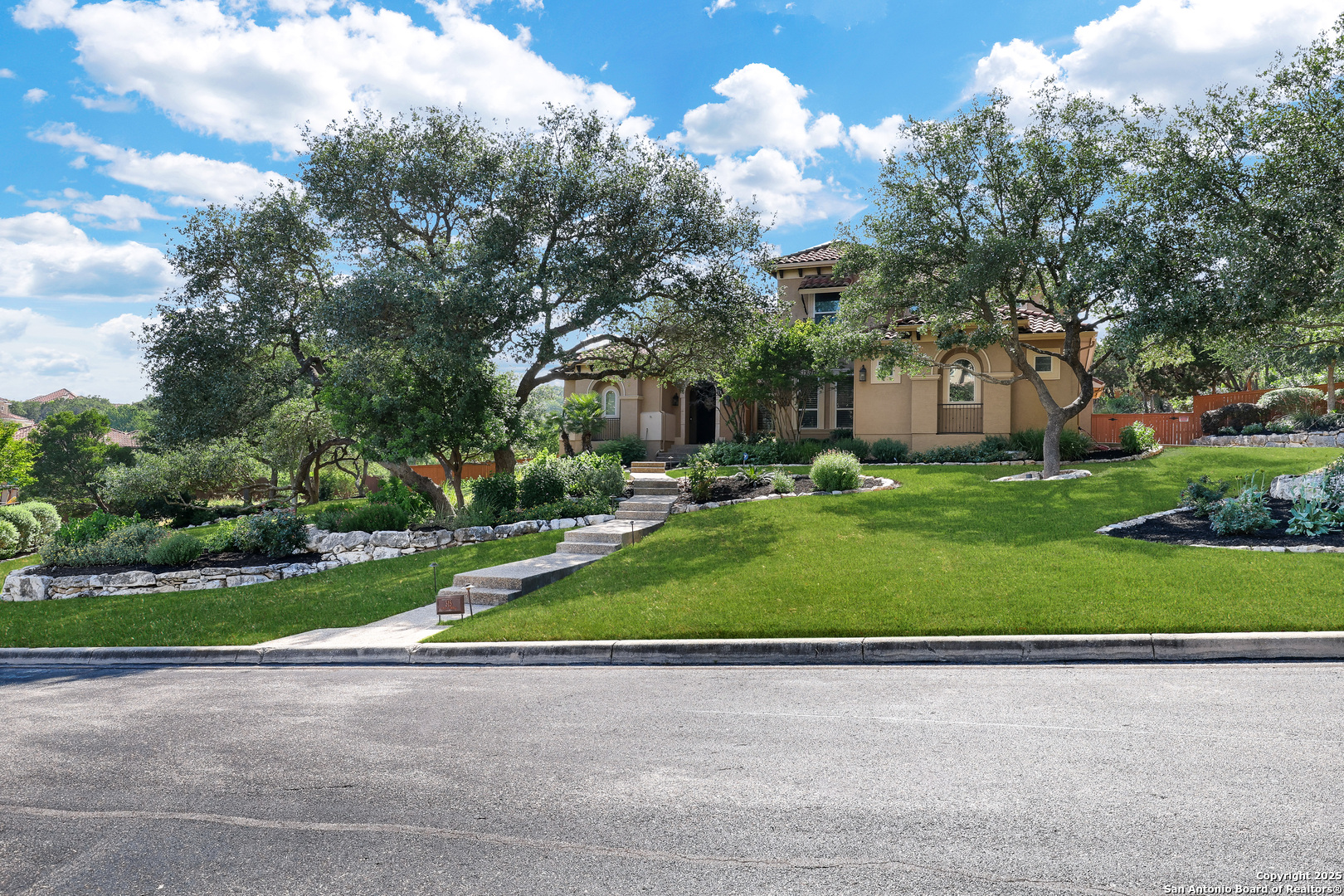 a view of a house with a big yard and large trees