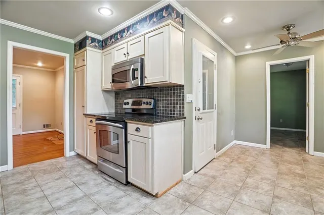 a kitchen with stainless steel appliances granite countertop a refrigerator and a stove