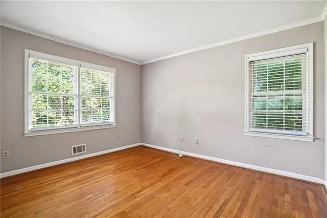 a view of an empty room with wooden floor