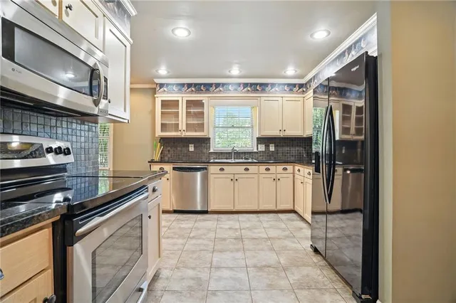 a kitchen with stainless steel appliances granite countertop a stove a sink and a refrigerator