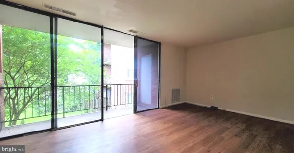 a view of a big room with wooden floor and doors