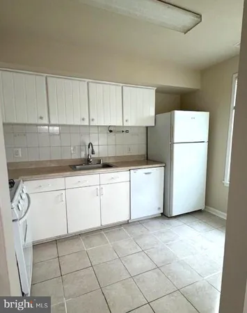 a kitchen with a cabinets a sink and a refrigerator
