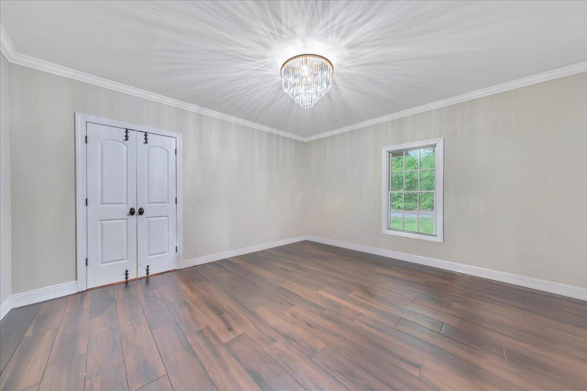 640 Flanders Road Callaway, VA 24067 - Photo 23 of 73 an empty room with wooden floor chandelier and windows