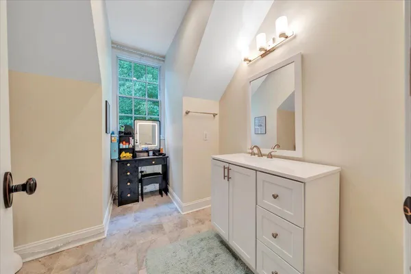 a living room with stainless steel appliances wooden floors and kitchen view