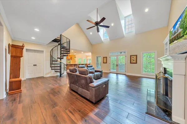 a open kitchen with stainless steel appliances granite countertop a stove a sink dishwasher and a dining table with wooden floor