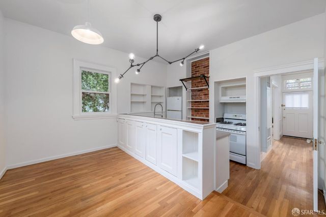 a kitchen with stainless steel appliances granite countertop a stove and cabinets with wooden floor