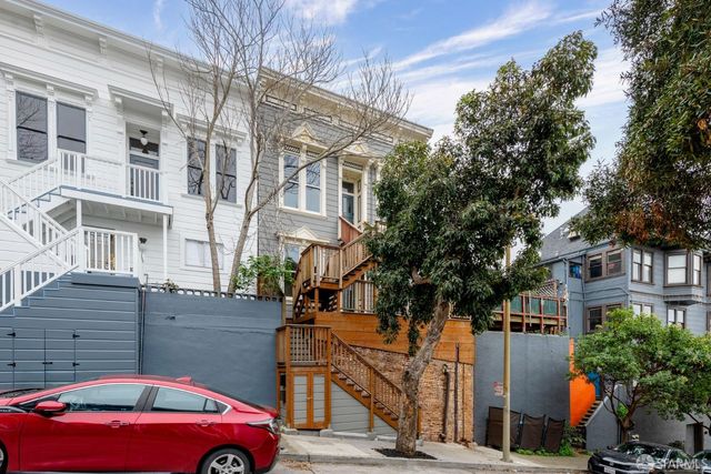 a front view of a building with large trees