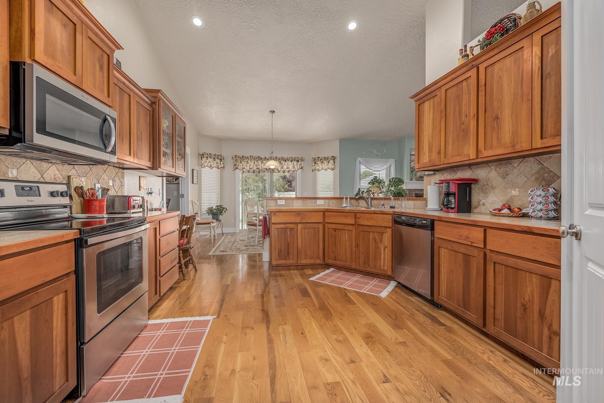 420 West Indianhead Road Weiser, ID 83672 - Photo 13 of 40 Kitchen featuring wood-finish flooring, stainless steel appliances, stone-look countertops, and recessed lighting