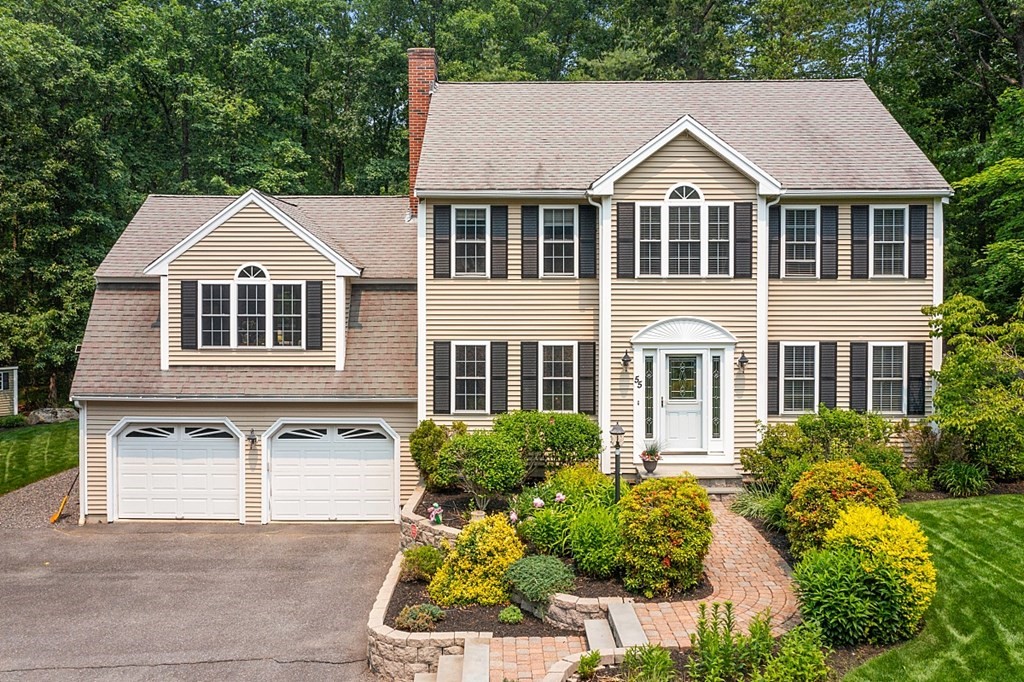a front view of a house with a yard and trees