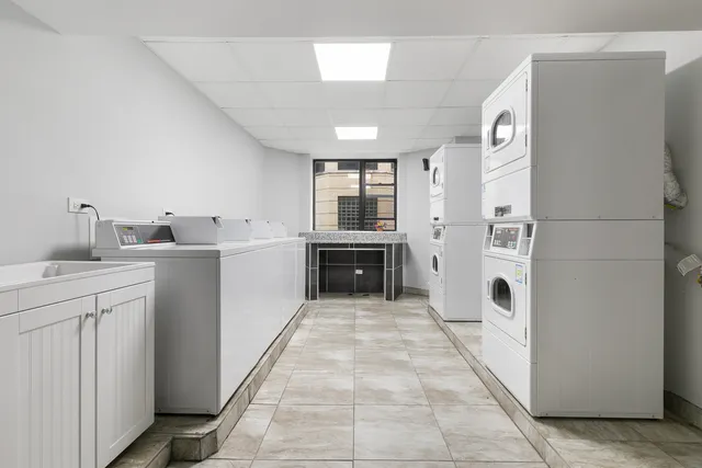 a large white kitchen with a sink a refrigerator and a stove