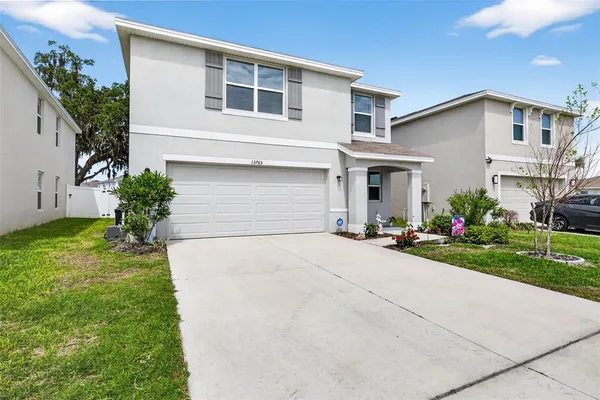 a front view of a house with a yard and garage