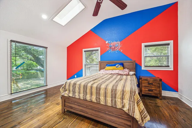 a bedroom with a bed and a dresser next to a window