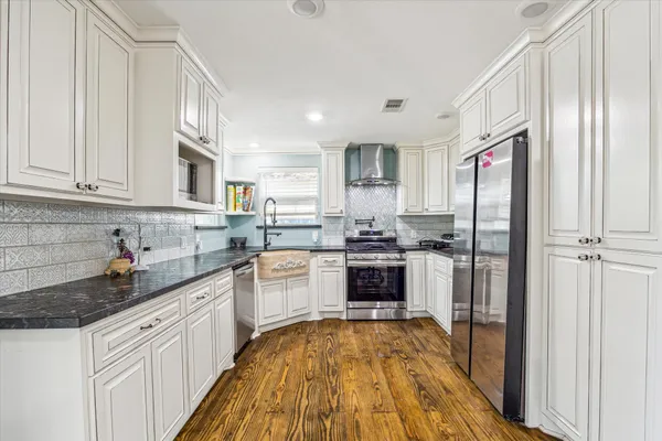 a kitchen with stainless steel appliances granite countertop a refrigerator sink and stove