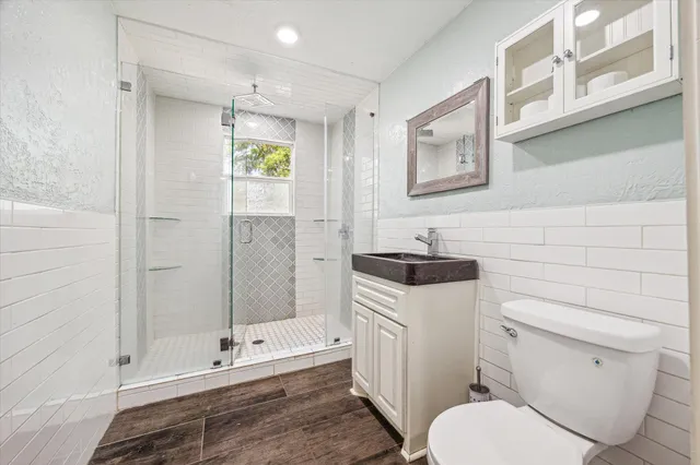 a bathroom with a granite countertop toilet sink and shower