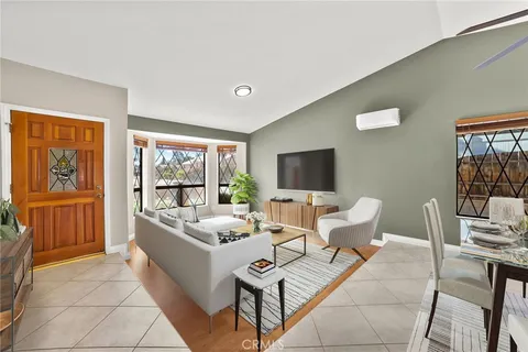 a living room with furniture a flat screen tv and a window