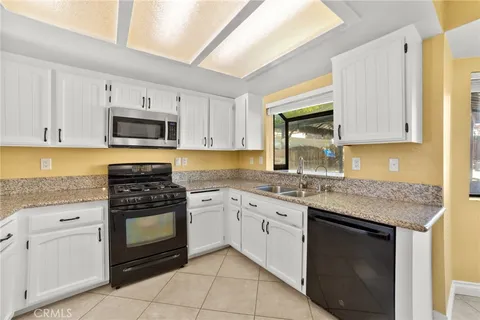 a kitchen with granite countertop a stove sink and cabinets
