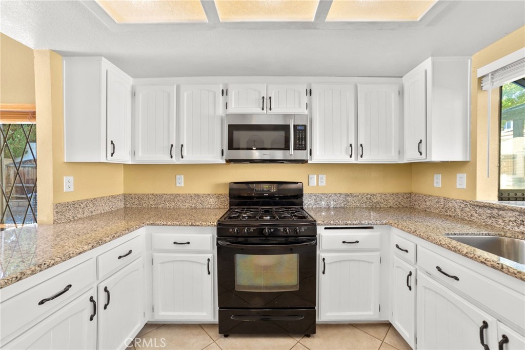 17800 Rancho Bonita Road Victorville, CA 92395 - Photo 10 of 52 a kitchen with granite countertop white cabinets and stainless steel appliances