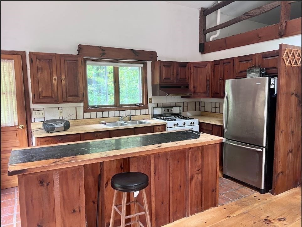 12 Sears Road Sandisfield, MA 01255 - Photo 11 of 22 a kitchen with stainless steel appliances granite countertop a refrigerator a sink a stove a washer and dryer with wooden floor